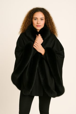 Black cashmere cape with black fox fur collar and trim, worn by a model.