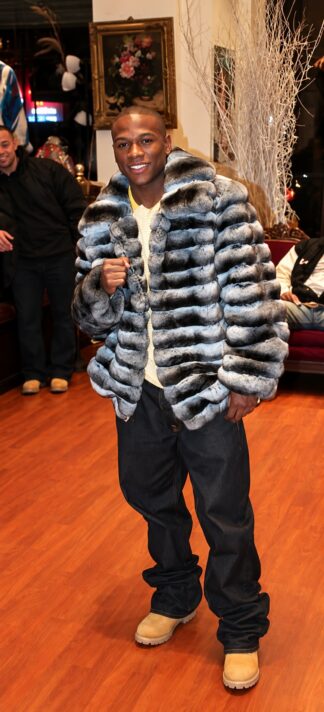 Floyd Mayweather in the blue chinchilla fur bomber jacket, full length with dark jeans and tan boots