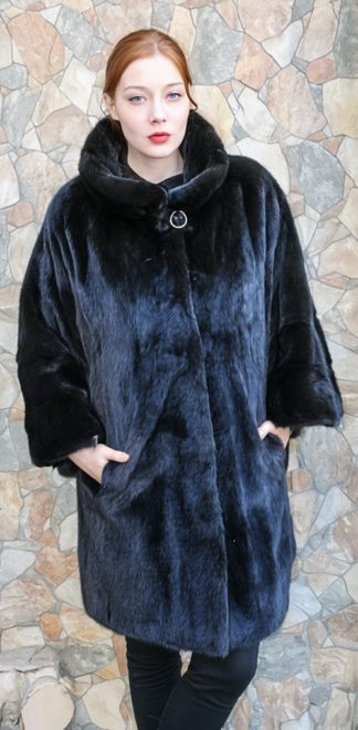 Blackglama ranch mink cape stroller with a shawl collar, wide cuffs, and side slit pockets, worn.
