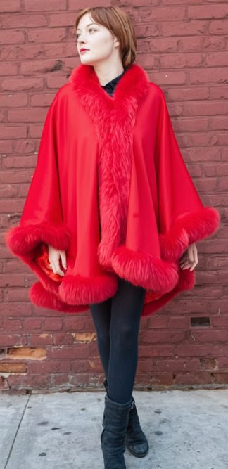 Red dyed fox border frames a hip-length red cashmere cape with a soft shawl collar.