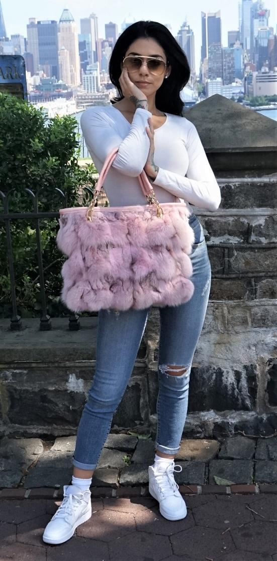 A woman holding a pink fur bag