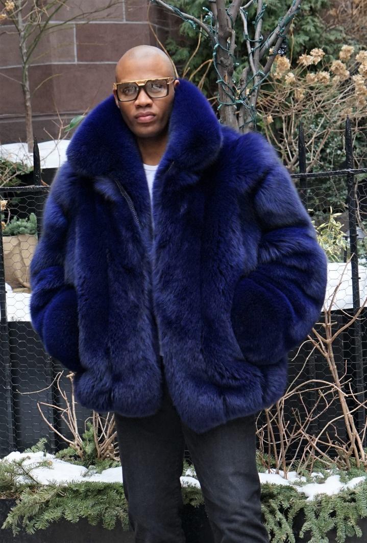A person wearing a blue fur bomber jacket