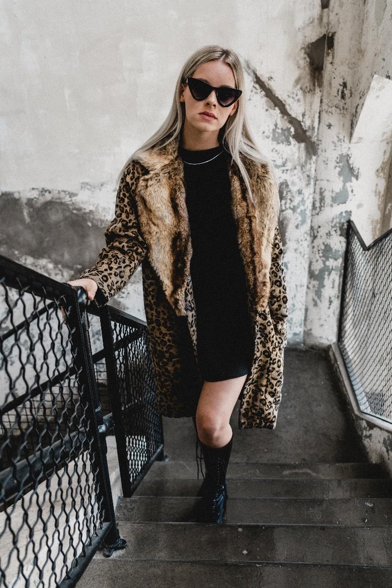 A woman wearing a faux fur leopard print coat