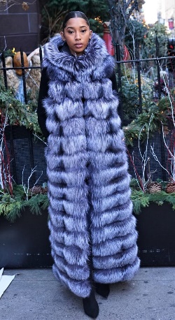 A woman wearing a blue fur coat made of fox fur 