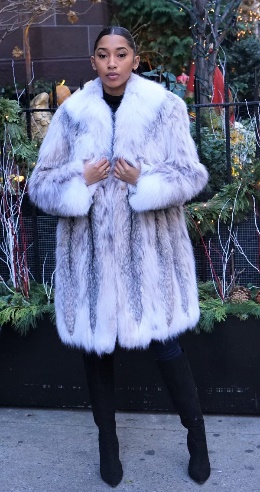 A woman wearing a white fur coat